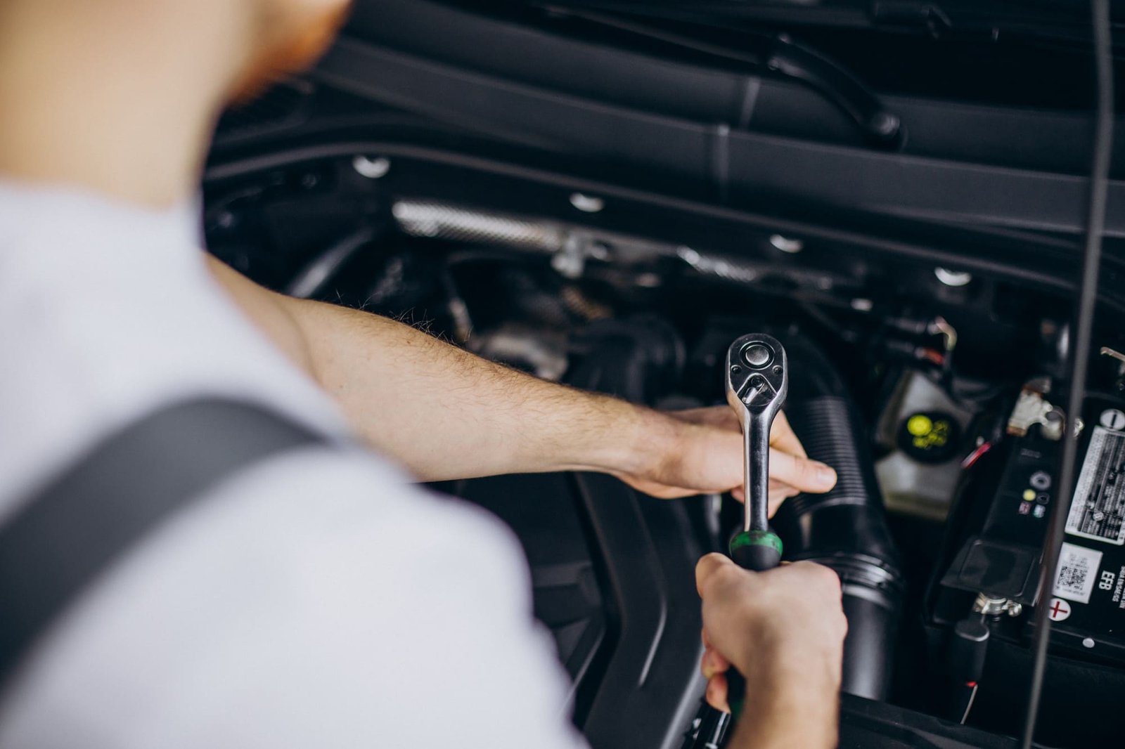 Mechaniker arbeitet mit Ratsche am Motor